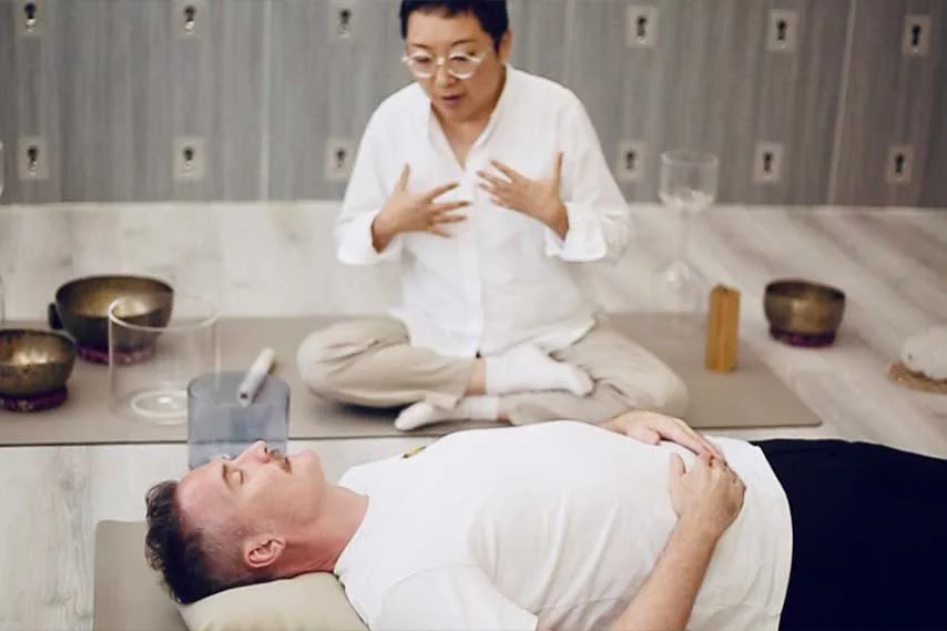 Breathwork facilitator, Anita teaches breathing technique to a student.